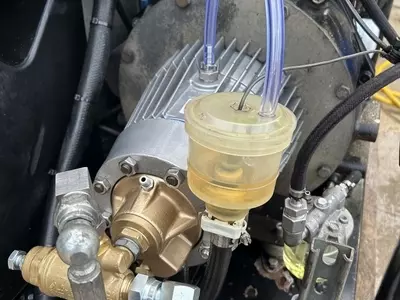 Refurbished Nilfisk C3 pressure washer pump installed alongside unloader valve during industrial diesel hot pressure washer repair in Dover.